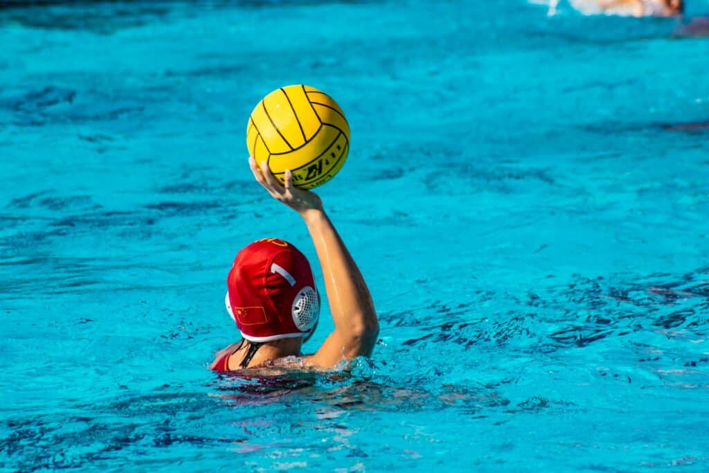 a person in a pool with a ball in their hand